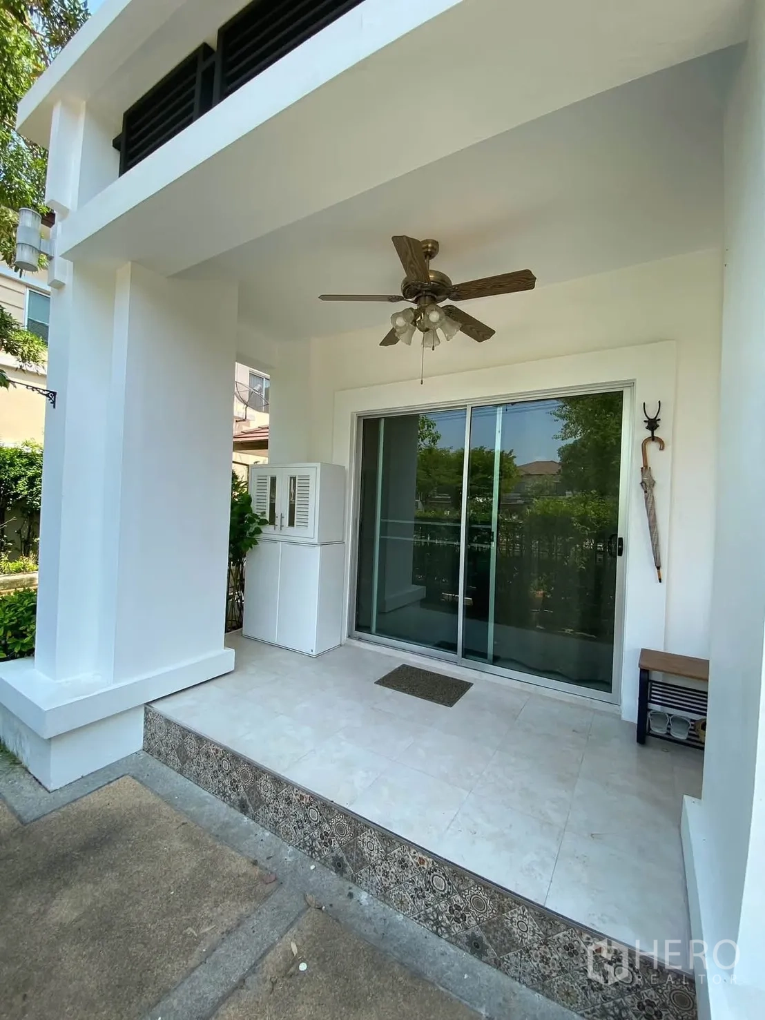 独栋房屋 for rent in Mueang Samut Prakan, Samut Prakan - 前廊带吊扇与推拉玻璃门，空间开阔。