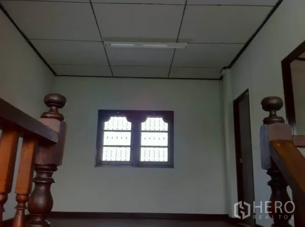 Warehouse for rent in Lam Luk Ka, Pathum Thani - Upper hall with a drop ceiling, small window and wooden staircase posts.