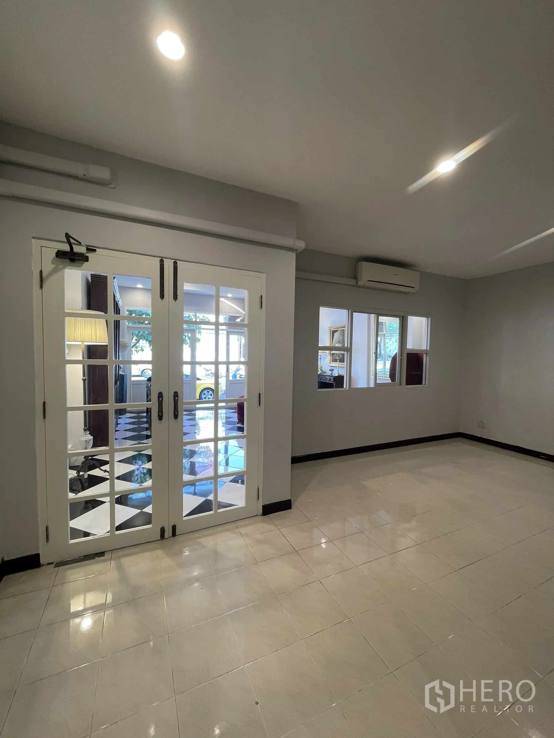 店屋 for rent in Bang Kapi, Bangkok - 办公或会客室，亮面地砖与法式双开玻璃门通向棋盘格大堂。