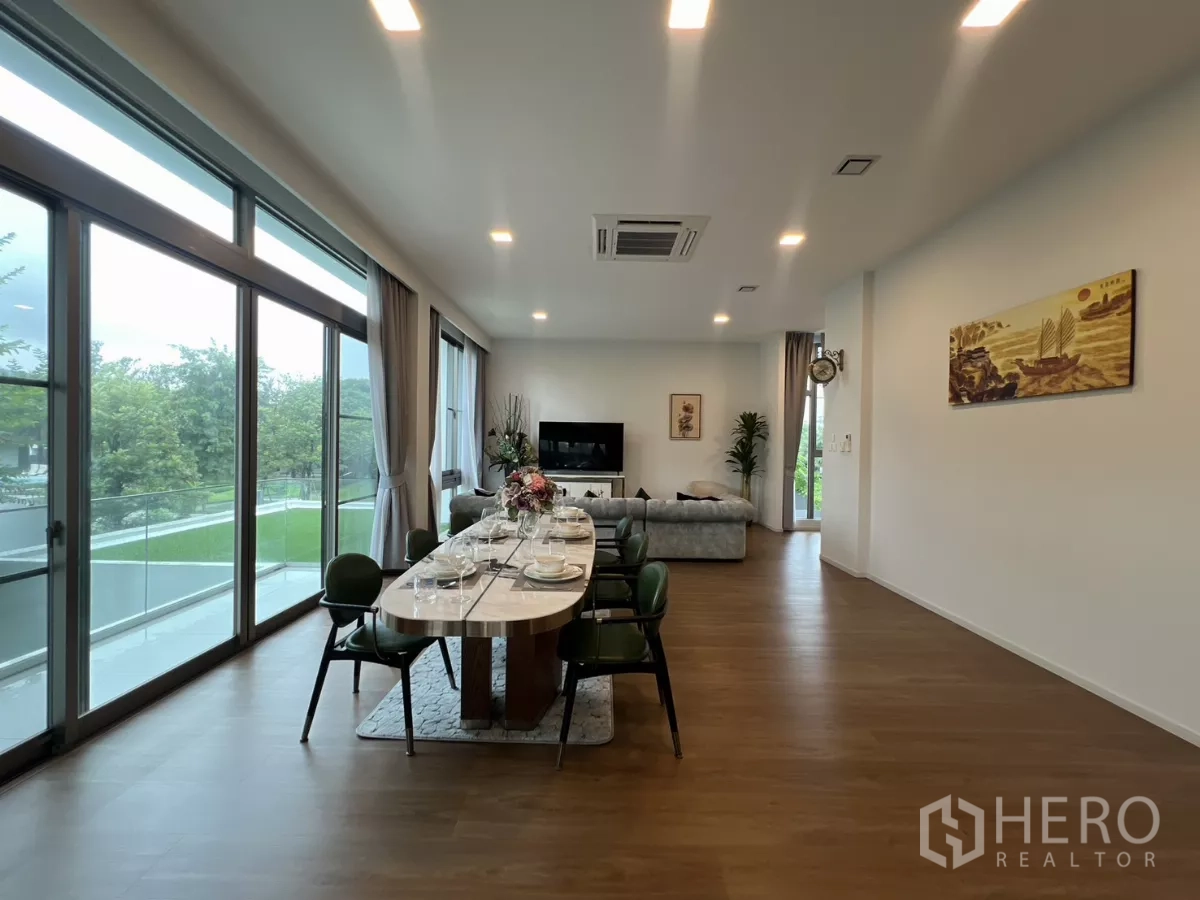 Detached House for rent in Saphan Sung, Bangkok - Dining and living space opening to a balcony with wide glazing and greenery views.