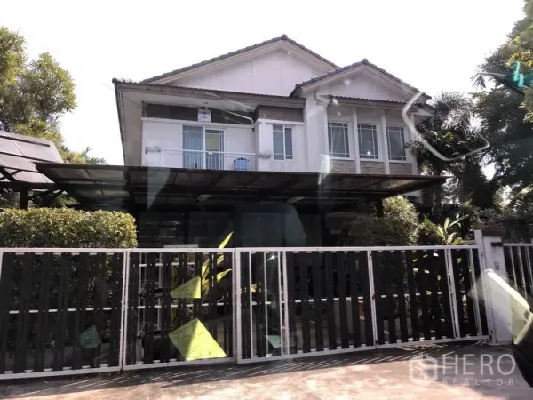 独立式住宅 出售在Bang Kapi, Bangkok - Bang Kapi 两层独栋住宅，带推拉金属围栏、带顶车棚、大面积窗户与前庭绿植。