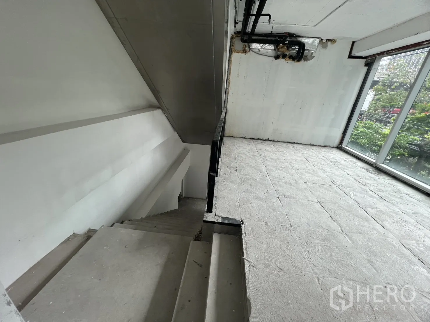 零售空间 出租在Bang Rak, Bangkok - 楼梯与夹层平台细节，旁有整面玻璃墙。