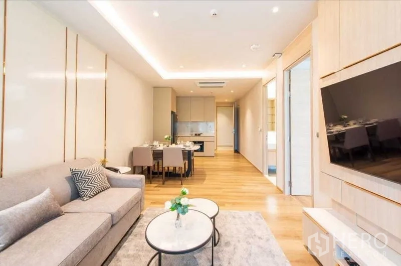 公寓 出租在Bang Na, Bangkok - 开放式起居区，沙发、双茶几、餐桌与小厨房一体化布局。