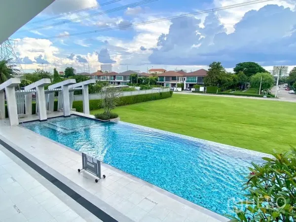 独立式住宅 出租在Prawet, Bangkok - 社区泳池与池畔步道，眺望大片草坪与邻里住宅
