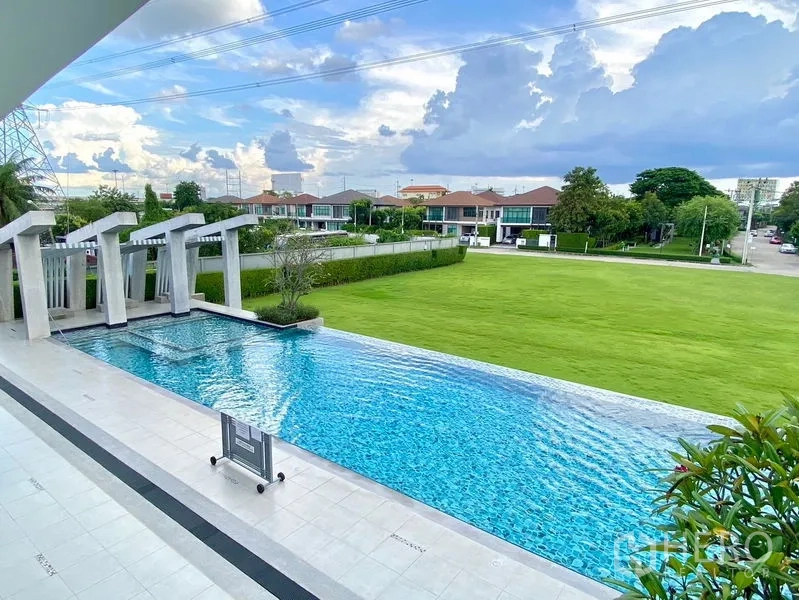 独立式住宅 出租在Prawet, Bangkok - 社区泳池与池畔步道，眺望大片草坪与邻里住宅