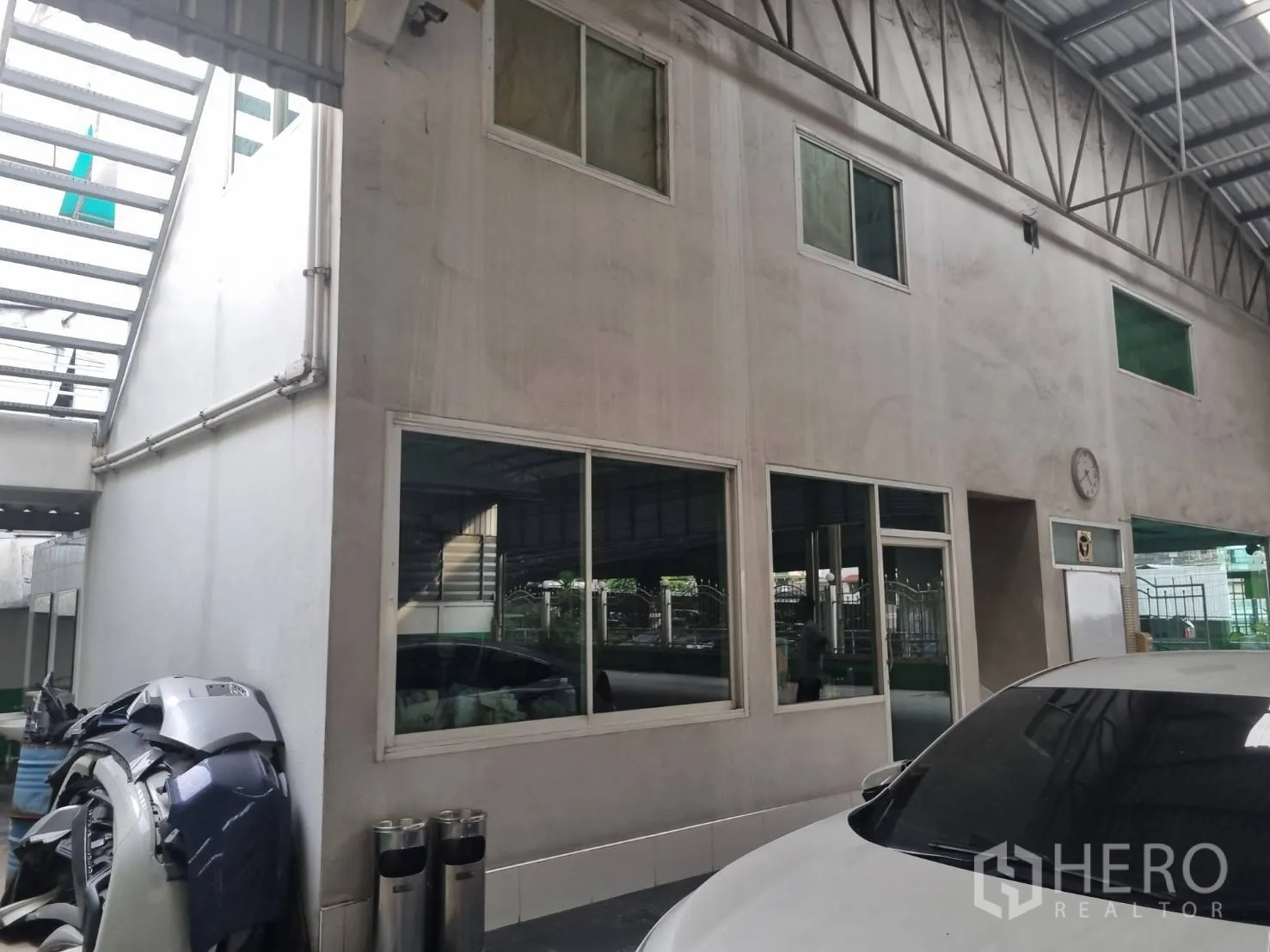 Warehouse for sale in Yan Nawa, Bangkok - Two-storey office block inside the warehouse with windows and adjacent parking area.