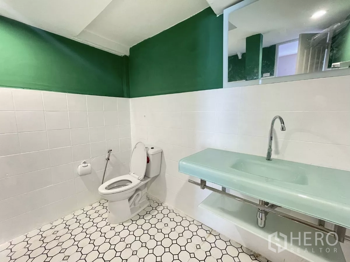 Home Office for rent in Din Daeng, Bangkok - Modern restroom with green and white walls, hexagon tile floor and a long glass sink.