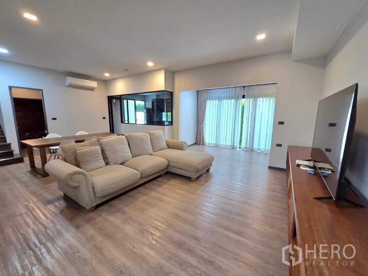 Detached House for rent in Bang Phli, Samut Prakan - Open-plan lounge with TV console, full-height curtains and sliding doors to the garden.