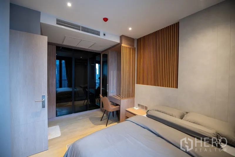 Condominium for rent in Din Daeng, Bangkok - Bedroom with built-in desk, bedside table and mirrored wardrobe doors for extra storage.