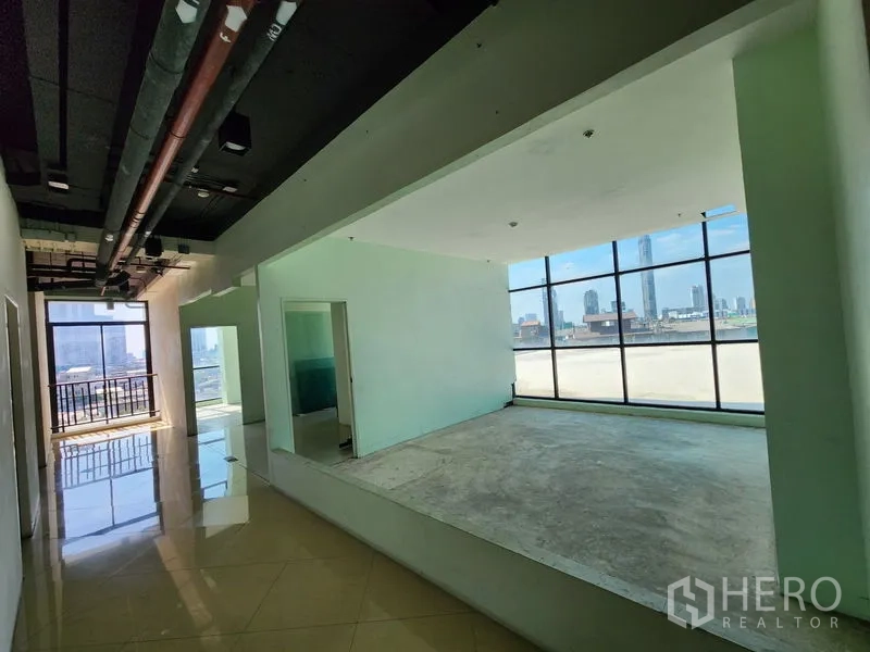 Retail Space for rent in Bang Rak, Bangkok - Open-plan zone with raised platform, exposed ceiling, and large windows.