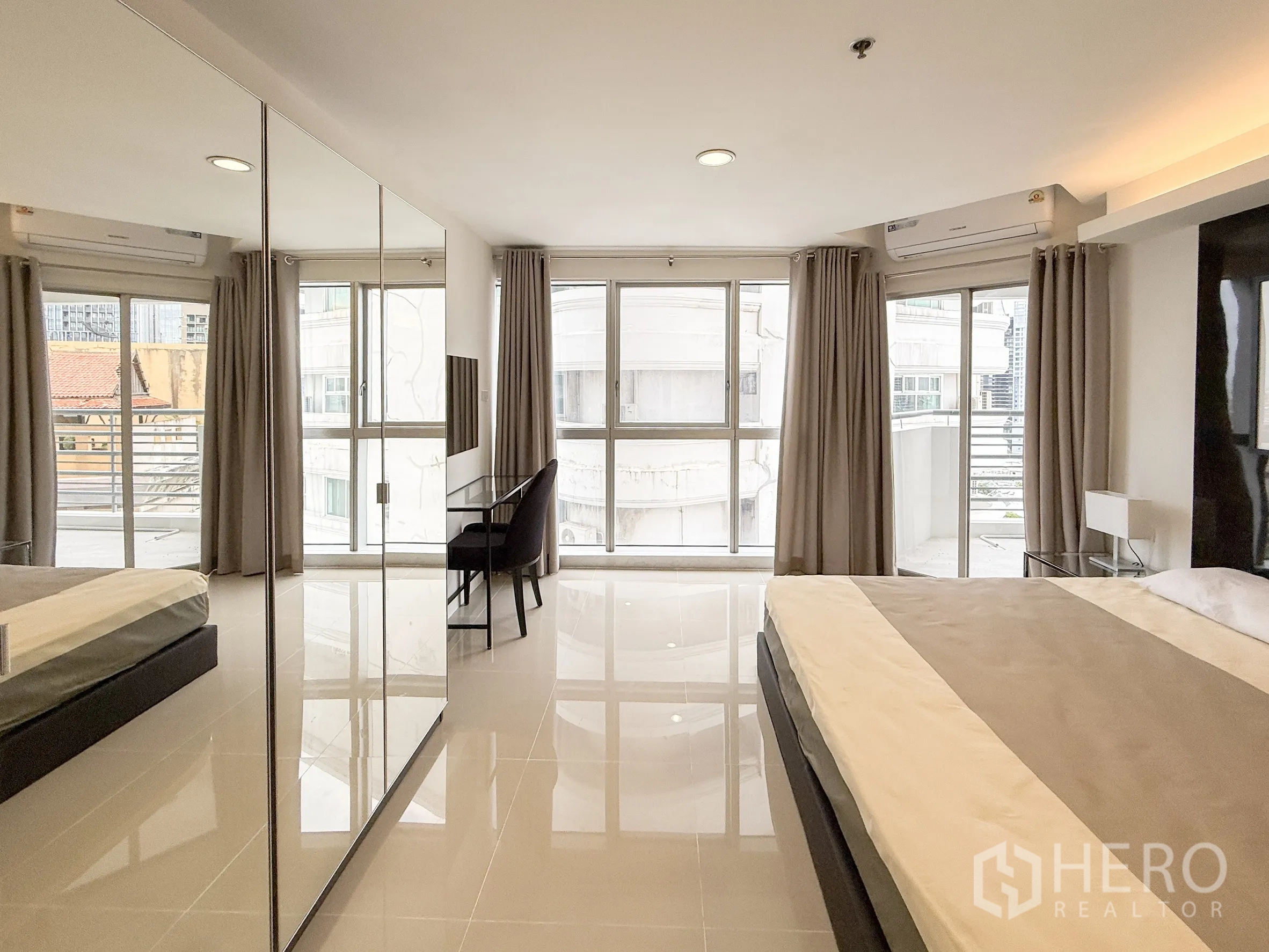 公寓 出租在Khlong Toei, Bangkok - 转角卧室，环绕落地窗、镜面衣柜并可通往小阳台。