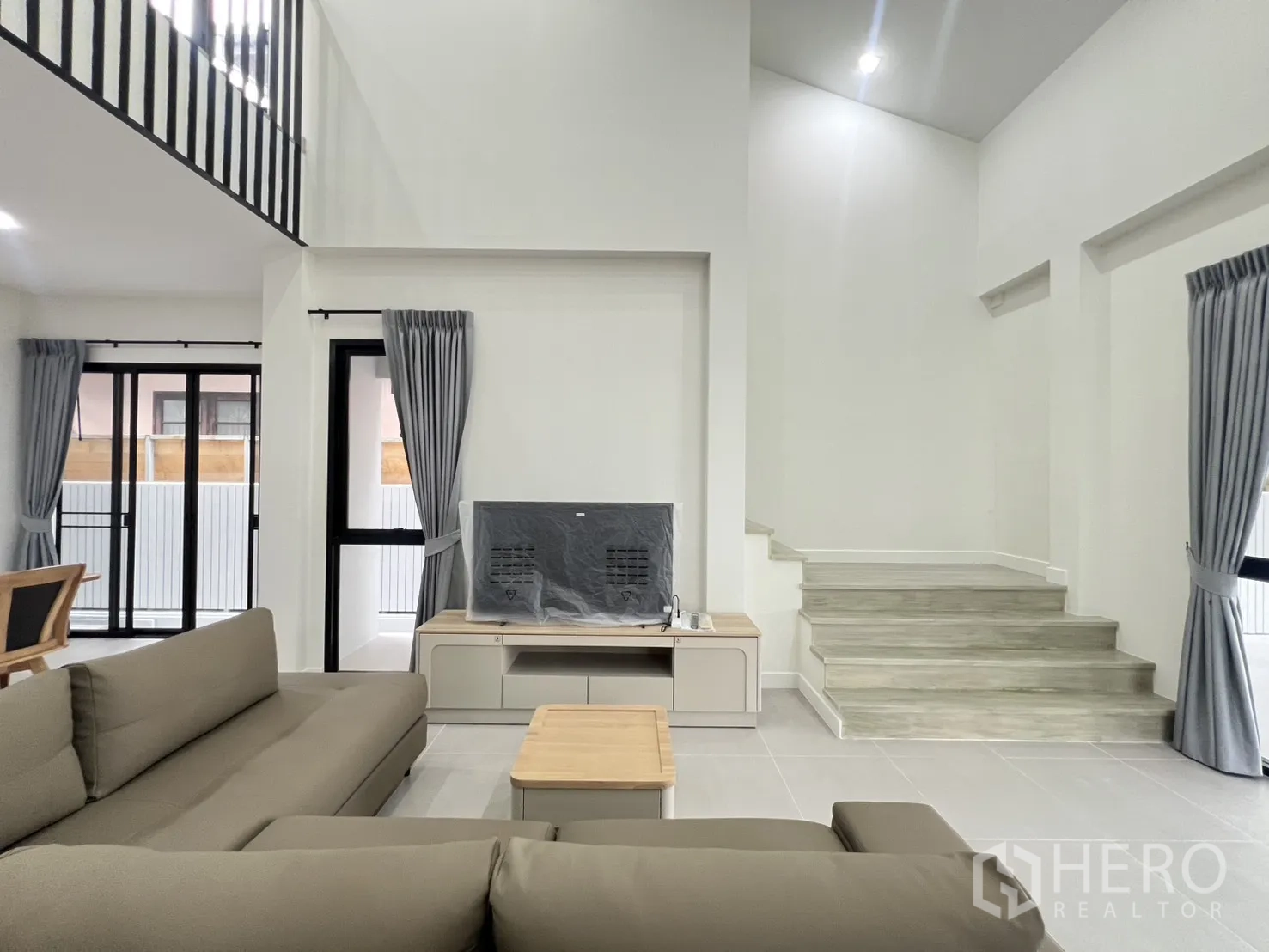 บ้านเดี่ยว for rent in Saphan Sung, Bangkok - โถงเพดานสูง มีหน้าต่างสูงจรดเพดานและผ้าม่านสีเทา
