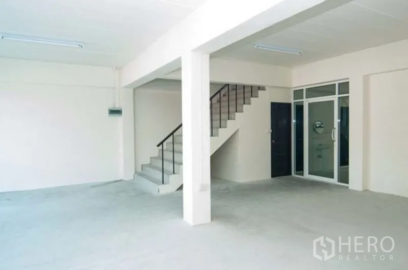 Factory for rent in Bang Sao Thong, Samut Prakan - Ground-floor office area with staircase and glass entrance door.