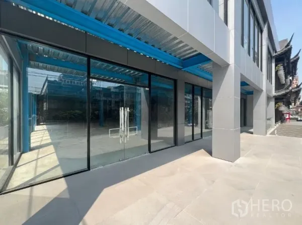 Retail Space for rent in Huai Khwang, Bangkok - Row of floor-to-ceiling glass shopfronts with a wide paved walkway and canopy for signage and displays.