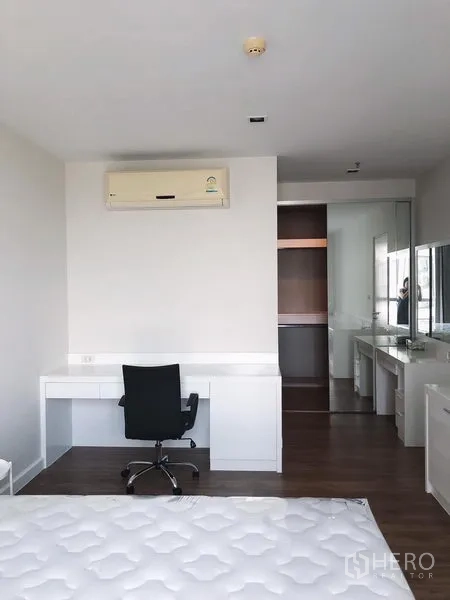 Condominium for rent in Bang Rak, Bangkok - Primary bedroom with work desk, swivel chair, air conditioner and built-in wardrobe with vanity.