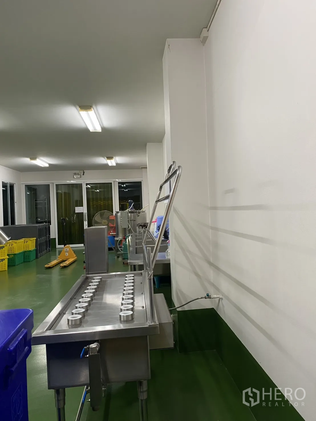 Factory for sale in Khlong Luang, Pathum Thani - Stainless processing table with multiple holders in a well-lit cleanroom.
