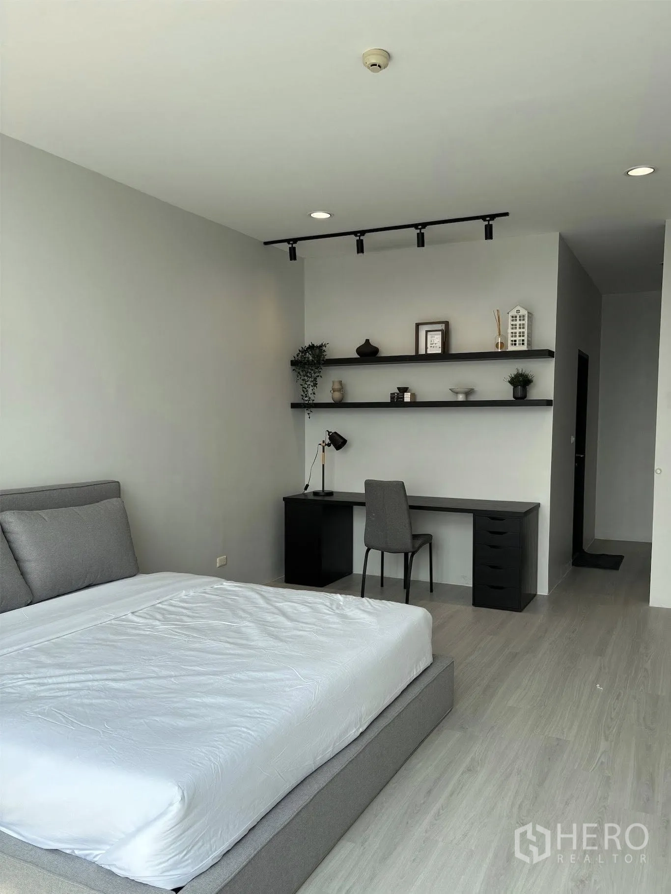 คอนโด for rent in Ratchathewi, Bangkok - ห้องนอนพร้อมชั้นวางของติดผนัง โต๊ะทำงานยาว และเตียงแพลตฟอร์มสีเทา