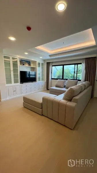 Condominium for rent in Watthana, Bangkok - Another view of the living area showing TV built-ins, cove lighting and a large window for natural light.