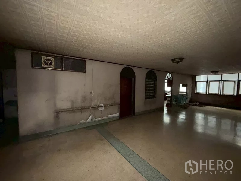 Shophouse for rent - Vintage-style room with patterned ceiling, arched doorway and frosted windows.