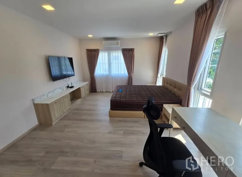 独立式住宅 for rent in Bang Phli, Samut Prakan - 宽敞主卧，设床、书桌、壁挂电视与多扇采光窗。