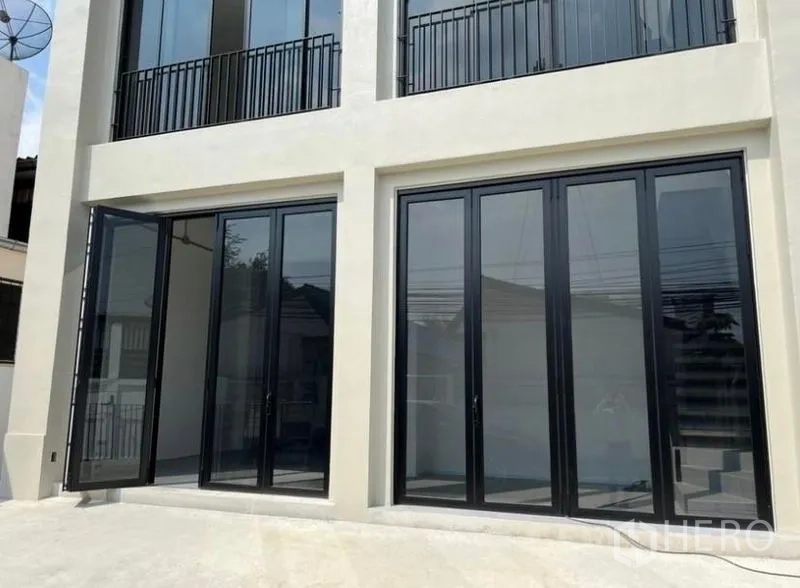 Home Office for rent or sale in Bang Na, Bangkok - Ground-floor glass facade with black-framed folding doors on the home office exterior.