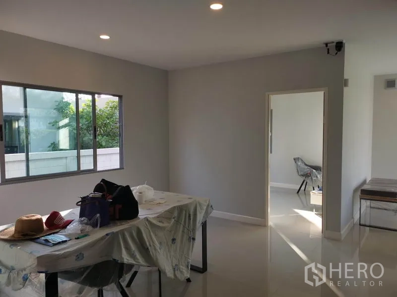 独立式住宅 出售在Nonthaburi - 餐区设大窗和筒灯，旁连多功能房