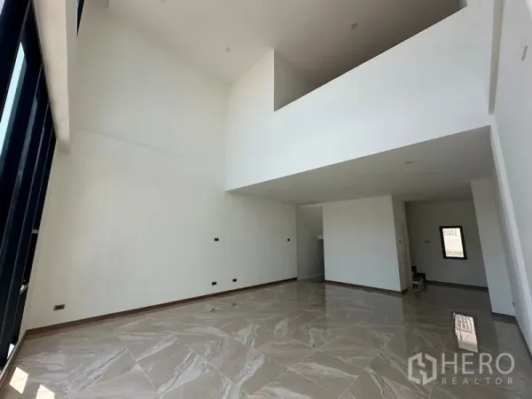 Home Office for rent in Wang Thonglang, Bangkok - Double-height living area with mezzanine and polished tile flooring, ready for showroom or office use.