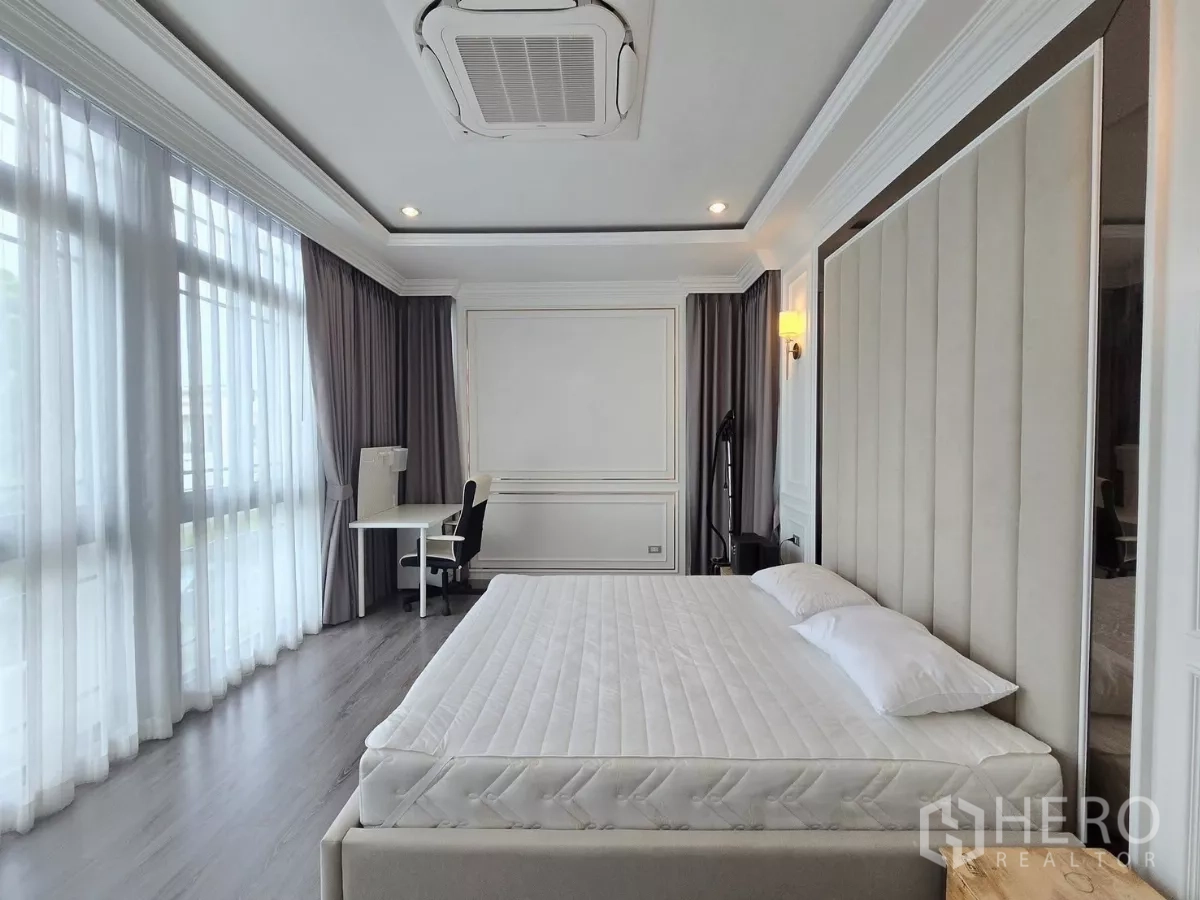 独立式住宅 出租在Prawet, Bangkok - 主卧带窗边书桌与层叠灰色窗帘。
