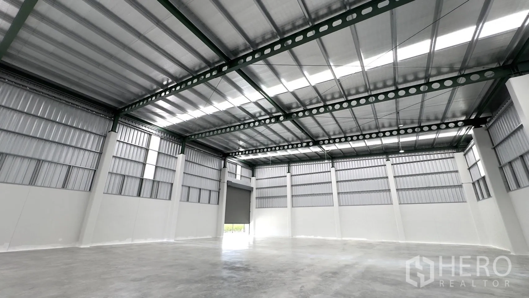 Factory for rent or sale in Bang Yai, Nonthaburi - Warehouse interior showing high insulated roof, steel trusses and polished concrete floor.