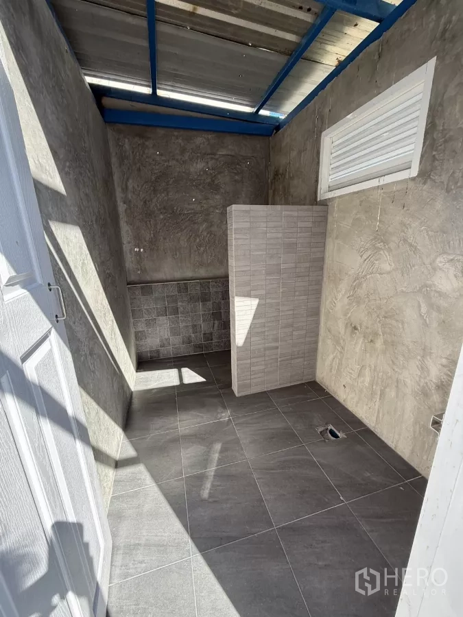Warehouse for rent in Lam Luk Ka, Pathum Thani - Warehouse restroom with tiled floor and partition in an industrial finish.