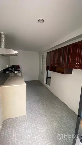 联排别墅 出租在Bang Na, Bangkok - 封闭式泰式厨房，长操作台、油烟机与木质橱柜。