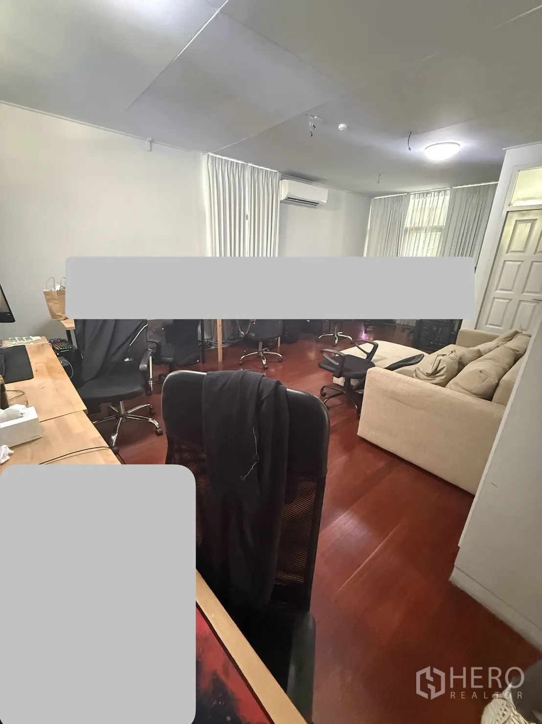 家庭办公室 for rent in Watthana, Bangkok - 大型工作间配长桌多座位、沙发与窗帘，木地板质感温暖。