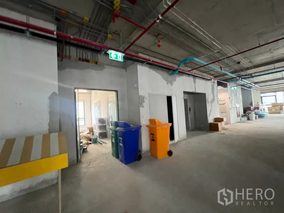 办公空间 出租在Khlong Toei, Bangkok - 办公区走廊，裸露机电管线、紧急出口指示与服务间。