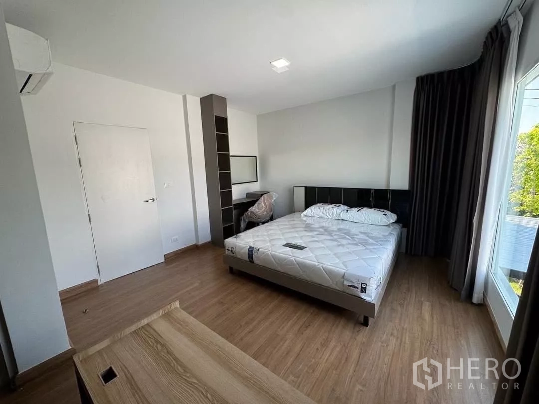 Detached House for rent in Bang Phli, Samut Prakan - Master bedroom from another angle showing bed, built-in shelving and a desk nook.