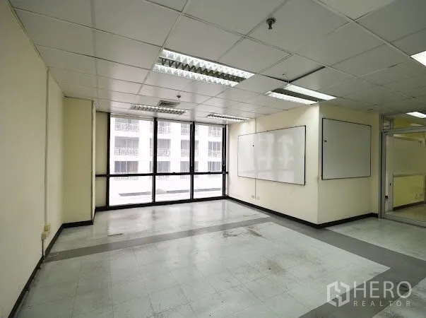 办公空间 出租在Watthana, Bangkok - 开放办公室，宽大窗户、两块白板与浅色瓷砖地面。