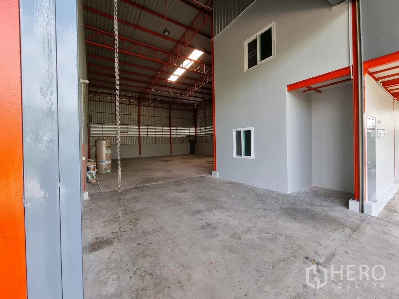 Warehouse for rent in Lam Luk Ka, Pathum Thani - Warehouse entry with roller door, internal office block and concrete floor.