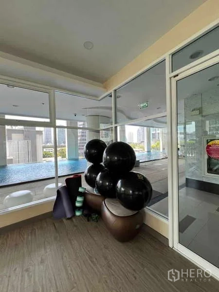 公寓 出租在Ratchathewi, Bangkok - 泳池旁瑜伽拉伸区，配健身球与垫子。