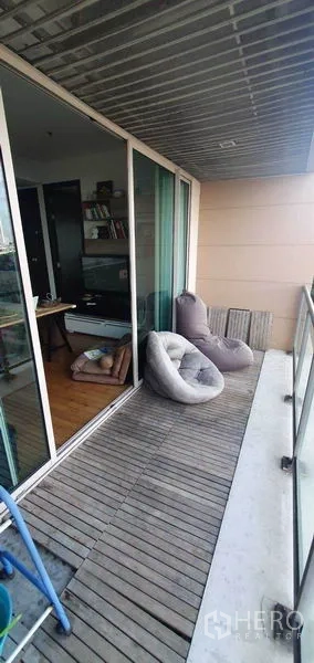 公寓 出租在Yan Nawa, Bangkok - 有顶阳台，木质地坪与懒人沙发座。