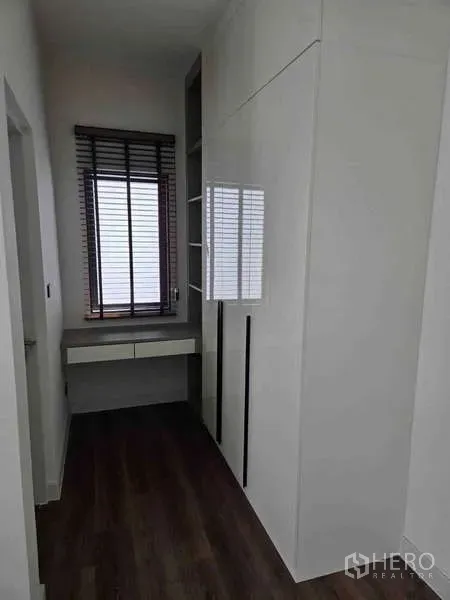 Detached House for rent in Bang Phli, Samut Prakan - Compact dressing corridor with built-in white wardrobes, desk and window blinds.