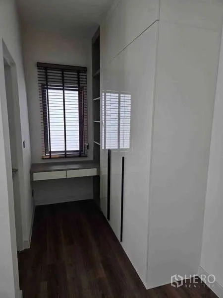 Detached House for rent in Bang Phli, Samut Prakan - Compact dressing corridor with built-in white wardrobes, desk and window blinds.