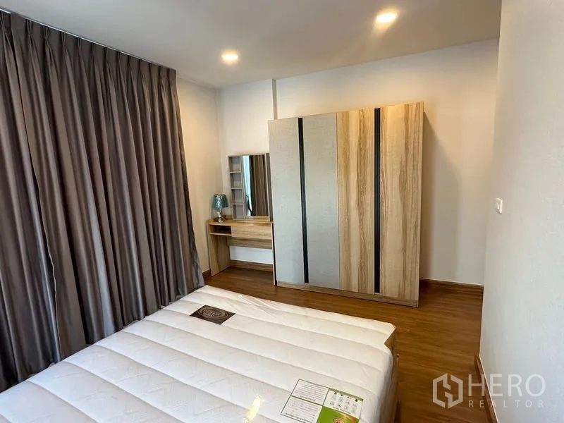 Detached House for rent in Bang Phli, Samut Prakan - Bedroom with dressing table, wardrobe and full-length curtains in neutral tones.