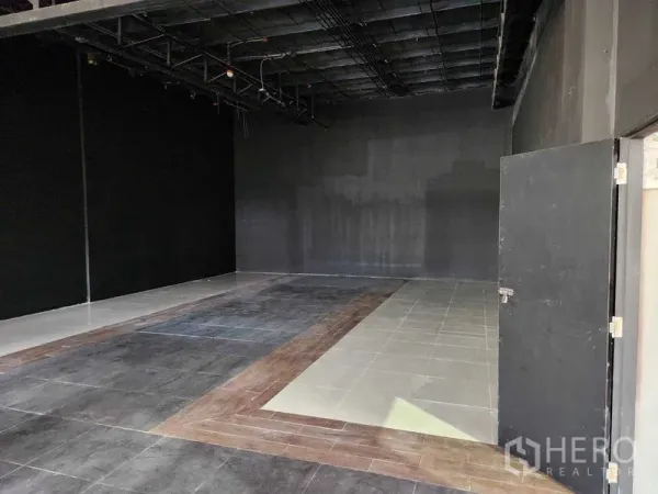 Retail Space for rent in Khlong Toei, Bangkok - Empty retail interior with mixed tile zones, black walls and exposed ceiling services ready for fit-out.