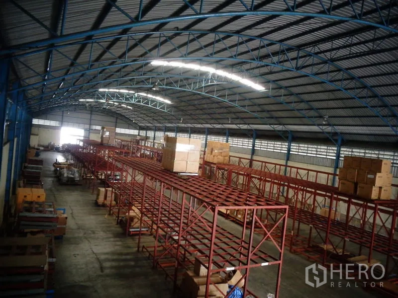 货栈 出租或出售在Lat Lum Kaeo, Pathum Thani - 深景通道视角，连续托盘货架与明亮条形照明。