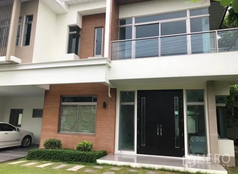 独立式住宅 出租在Lat Krabang, Bangkok - 立面特写，带阳台、大窗与双开入户门。