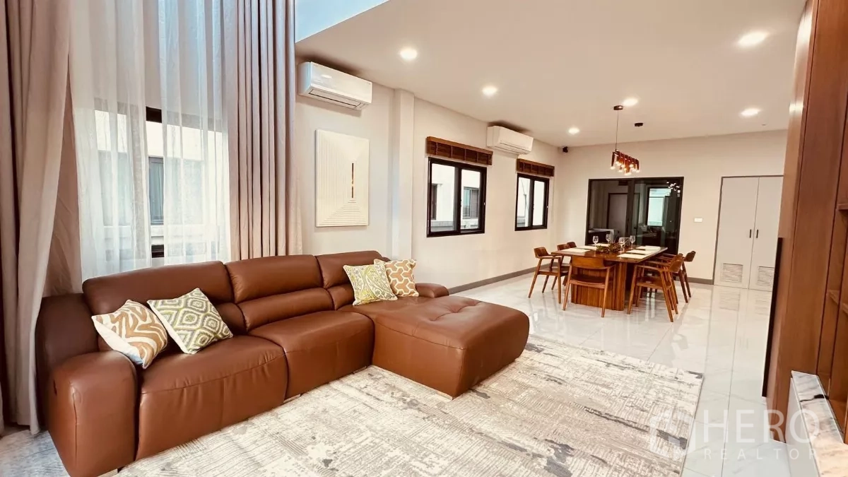 บ้าน ให้เช่าในBang Phli, Samut Prakan - พื้นที่พักผ่อนกว้าง โซฟาหนังสีน้ำตาล หน้าต่างหลายบานและไฟดาวน์ไลท์