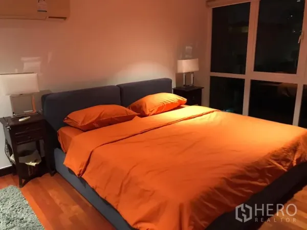 Condominium for rent in Watthana, Bangkok - Primary bedroom with king-size bed, bedside tables and a floor-to-ceiling window.