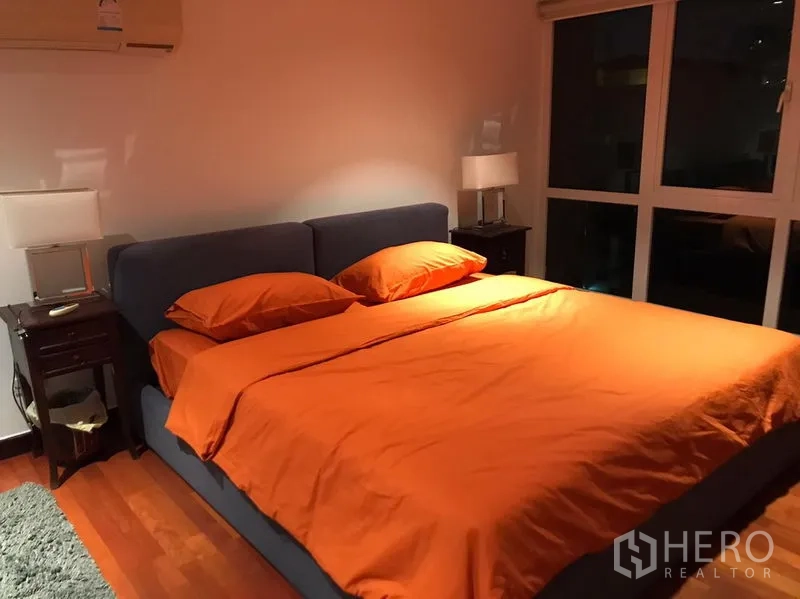 Condominium for rent in Watthana, Bangkok - Primary bedroom with king-size bed, bedside tables and a floor-to-ceiling window.