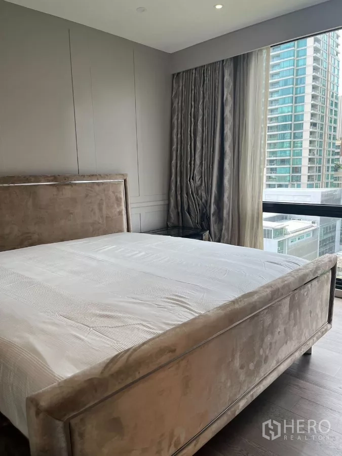 公寓 出租在Pathum Wan, Bangkok - 主卧设软包床，落地窗眺望城市天际线。