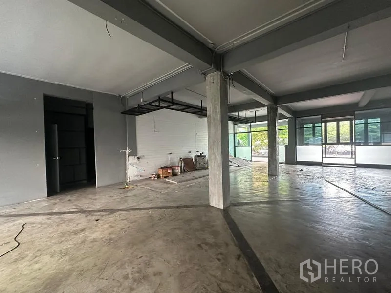 Retail Space for rent - Open retail layout with a white brick feature wall, metal ceiling racks and large glass doors.