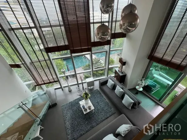 Condominium for sale in Khlong San, Bangkok - View from the mezzanine over the living room with floor-to-ceiling windows and swimming pool outlook.